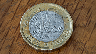 A one pound coin GBP on a wooden surface