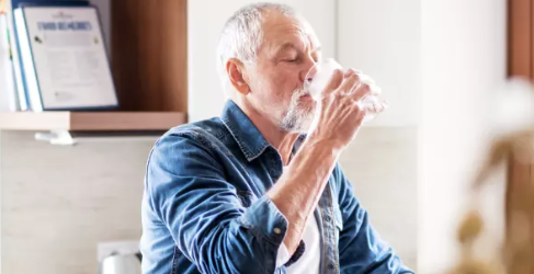 Older man drinking a glass of water