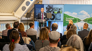 View of audience attending the annual ACM at Dundee Science Centre with CEO Alex Plant at the lecturn