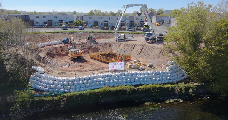 A construction site on the bank of the River Nith in Dumfries. A large crane is visible at the back of the photograph.