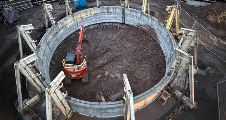 A construction vehicle is shown within the site of a storm tank
