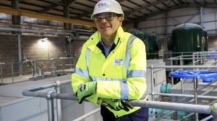Scottish Water CEO, Alex Plant, in high-visibility overalls and hard hat
