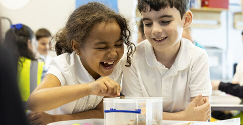 Boy and girl from Dunard Primary laughing whist engaging with water cycle in a box experiment at Glasgow Science Centre