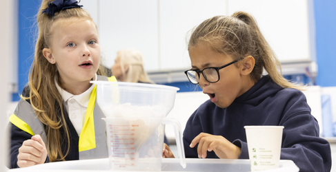 Two girls from Dunard Primary School watching water filter in an experiment at Glasgow Science Centre