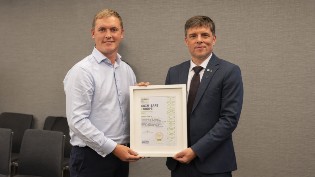 Gordon Hunter from Scottish Swimming being presented by Rókur í Jákupsstovu from European Aquatics with the gold standard certificate.