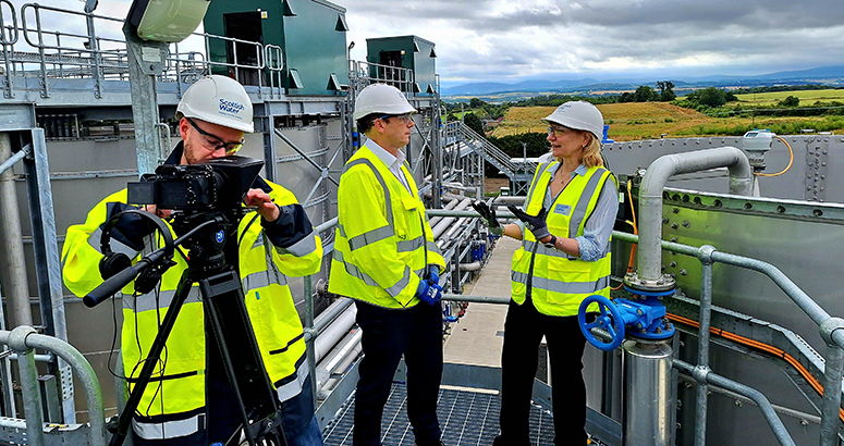 Scottish Water chair Deirdre Michie and CEO Alex Plant being filmed by a cameraman at Winchburgh waste water treatment works on a sunny day