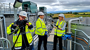 Scottish Water chair Deirdre Michie and CEO Alex Plant being filmed by a cameraman at Winchburgh waste water treatment works on a sunny day
