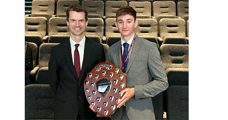 Zac Mooney pictured holding his award beside mentor John Lenehan