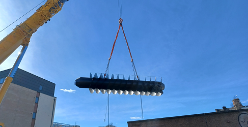 The screw pump is shown in the air as it is being transferred to site