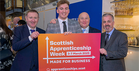 Scottish Water apprentice Cameron Clark with a group holding a sign promoting Scottish Apprenticeship Week 2025