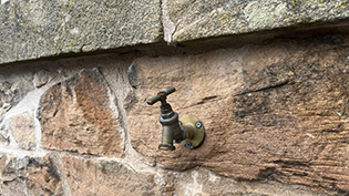 outdoor garden tap on a stone wall